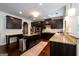 Open concept kitchen with dark wood cabinets, granite counters, island, and stainless steel appliances at 145 Seawright Dr, Fayetteville, GA 30215