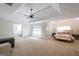 Spacious main bedroom suite with tray ceilings, a ceiling fan, and a seating area offering comfort and style at 145 Seawright Dr, Fayetteville, GA 30215
