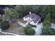 An aerial view of a charming stucco house nestled among green trees with a well-manicured lawn at 433 Abbey Springs Way, Mcdonough, GA 30253