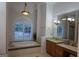 Bathroom with a bathtub, arched window, vanity, and large mirror at 433 Abbey Springs Way, Mcdonough, GA 30253