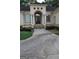 Stately beige home featuring column accents, stone steps, and arched doorway at 433 Abbey Springs Way, Mcdonough, GA 30253