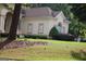 Beige stucco house with a brown roof and trimmed landscaping at 433 Abbey Springs Way, Mcdonough, GA 30253