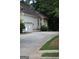 Side view of the home showcasing the driveway, garage, and well-maintained landscaping at 433 Abbey Springs Way, Mcdonough, GA 30253