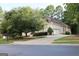 Home exterior featuring a spacious driveway, mature trees, and lush landscaping at 433 Abbey Springs Way, Mcdonough, GA 30253