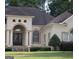 Charming home exterior featuring an arched entryway, well-manicured lawn, and elegant landscaping at 433 Abbey Springs Way, Mcdonough, GA 30253