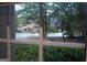 View of a driveway with a basketball hoop and a house on a large lot through a window at 433 Abbey Springs Way, Mcdonough, GA 30253