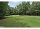 Lush backyard surrounded by mature trees offering privacy and shade with plenty of open grass area at 140 Alford Dr, Fayetteville, GA 30215