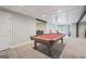 Spacious finished basement with dark ceiling beams and a pool table, adjacent to a seating area at 140 Alford Dr, Fayetteville, GA 30215