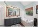 Bathroom with a large vanity, gray cabinets, and a soaking tub at 140 Alford Dr, Fayetteville, GA 30215