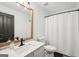 Bathroom featuring a large mirror, white cabinets, white sink, and a shower curtain at 140 Alford Dr, Fayetteville, GA 30215
