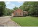 Brick home with attached garage, manicured lawn and surrounded by mature trees at 140 Alford Dr, Fayetteville, GA 30215