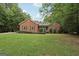 Inviting brick home with dormer windows and lush lawn surrounded by mature trees at 140 Alford Dr, Fayetteville, GA 30215