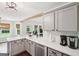 Bright kitchen has stainless steel appliances, grey cabinets, a view to the backyard, and hardwood floors at 140 Alford Dr, Fayetteville, GA 30215