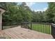 This wooden deck with black railings overlooks a grassy backyard at 140 Alford Dr, Fayetteville, GA 30215