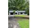 Charming ranch-style home with black two-car garage and surrounded by lush trees at 168 Park Ln, Dallas, GA 30157