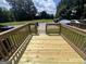 A newly refinished wooden back deck with traditional wood railings with an open view of the backyard at 160 Odyssey Turn, Conyers, GA 30012