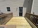 A newly refinished wooden back deck with traditional wood railings, leading to a black entry door at 160 Odyssey Turn, Conyers, GA 30012