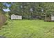 Backyard with a large grassy area, storage shed, and ' playground at 9138 Sunset Dr, Jonesboro, GA 30238