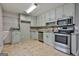 Spacious kitchen features stainless steel appliances, granite countertops, and sage-painted cabinets at 9138 Sunset Dr, Jonesboro, GA 30238