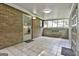 Enclosed sunroom boasts brick accent wall, ample natural light, and convenient access at 9138 Sunset Dr, Jonesboro, GA 30238