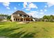 Expansive green backyard includes an outdoor firepit area, covered patio, and mature trees at 150 Dean Dr, Tyrone, GA 30290