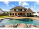Backyard features a sparkling pool, patio, and beautiful landscaping, ideal for entertaining at 150 Dean Dr, Tyrone, GA 30290
