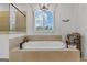 Relaxing bathroom with a soaking tub, glass-enclosed shower, and a window providing natural light at 150 Dean Dr, Tyrone, GA 30290