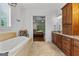 Open bathroom layout with soaking tub, wood vanity and backyard views at 150 Dean Dr, Tyrone, GA 30290