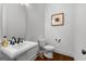 Simple, well-lit powder room featuring pedestal sink, toilet and framed wall art at 150 Dean Dr, Tyrone, GA 30290