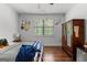 Bedroom with hardwood floors, large window, and armoire, with a cozy and inviting ambiance at 150 Dean Dr, Tyrone, GA 30290