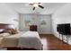 Bright bedroom with hardwood floors, ceiling fan, two windows, and a dark wooden furniture set at 150 Dean Dr, Tyrone, GA 30290