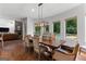 Open dining area with table adjacent to a living space with stone fireplace and pool views at 150 Dean Dr, Tyrone, GA 30290