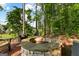 Backyard stone firepit with Adirondack chairs offers relaxing views of the wooded property at 150 Dean Dr, Tyrone, GA 30290