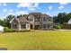 Impressive stone and brick home featuring a manicured lawn and classic architectural details at 150 Dean Dr, Tyrone, GA 30290