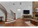 Inviting living room with hardwood floors, fireplace, and a staircase showcasing elegant design at 150 Dean Dr, Tyrone, GA 30290