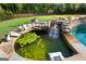 A serene pond with water feature is adjacent to the pool, surrounded by stone and lush landscaping at 150 Dean Dr, Tyrone, GA 30290