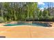 A luxury pool with a rock border and plenty of green trees for privacy at 150 Dean Dr, Tyrone, GA 30290