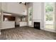 Open-concept living space with modern wood-look tile flooring, fireplace, and kitchen view at 2801 Priestcliff Dr, Smyrna, GA 30080