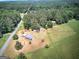 Overhead view of a property featuring a home, multiple outbuildings, and expansive fields surrounded by lush trees at 668 Spring Place Ne Rd, White, GA 30184