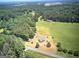 Wide aerial shot showcases a property with several outbuildings, surrounded by expansive lawns and mature trees at 668 Spring Place Ne Rd, White, GA 30184
