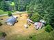 Bird's eye view capturing the full scope of the property and its various structures and the surrounding forest at 668 Spring Place Ne Rd, White, GA 30184