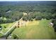 Aerial view showcases the property's extensive land and surrounding wooded areas at 668 Spring Place Ne Rd, White, GA 30184