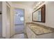 Bathroom featuring granite countertop, traditional mirror, and doorway view to the bedroom at 668 Spring Place Ne Rd, White, GA 30184