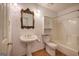 Bathroom featuring pedestal sink, commode and shower/tub combination with glass doors at 668 Spring Place Ne Rd, White, GA 30184