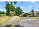 A gravel driveway leads to a metal carport attached to the house and adjacent to a red storage shed at 668 Spring Place Ne Rd, White, GA 30184