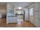 Bright kitchen with white cabinets, black countertops, and wood laminate flooring at 668 Spring Place Ne Rd, White, GA 30184