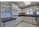 Updated kitchen with white cabinets, black granite countertops, and modern stainless steel appliances at 668 Spring Place Ne Rd, White, GA 30184