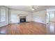 Inviting living room featuring hardwood floors, stone fireplace, and view to kitchen at 668 Spring Place Ne Rd, White, GA 30184