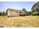 View of home's rear, showing back yard, deck, and carport in a well-maintained setting at 668 Spring Place Ne Rd, White, GA 30184