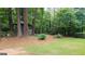 Serene backyard with green grass, mature trees, and a charming wooden gazebo for peaceful outdoor enjoyment at 2179 Mountclaire Ct, Stone Mountain, GA 30087